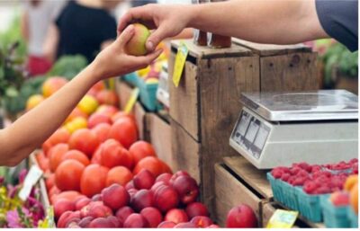 a person buying produce at a farmer's market